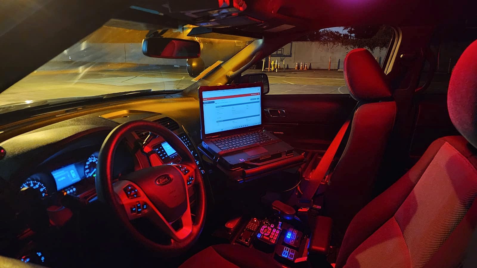 Interior of a Global One Security patrol vehicle showing the mounted reporting laptop and emergency controls